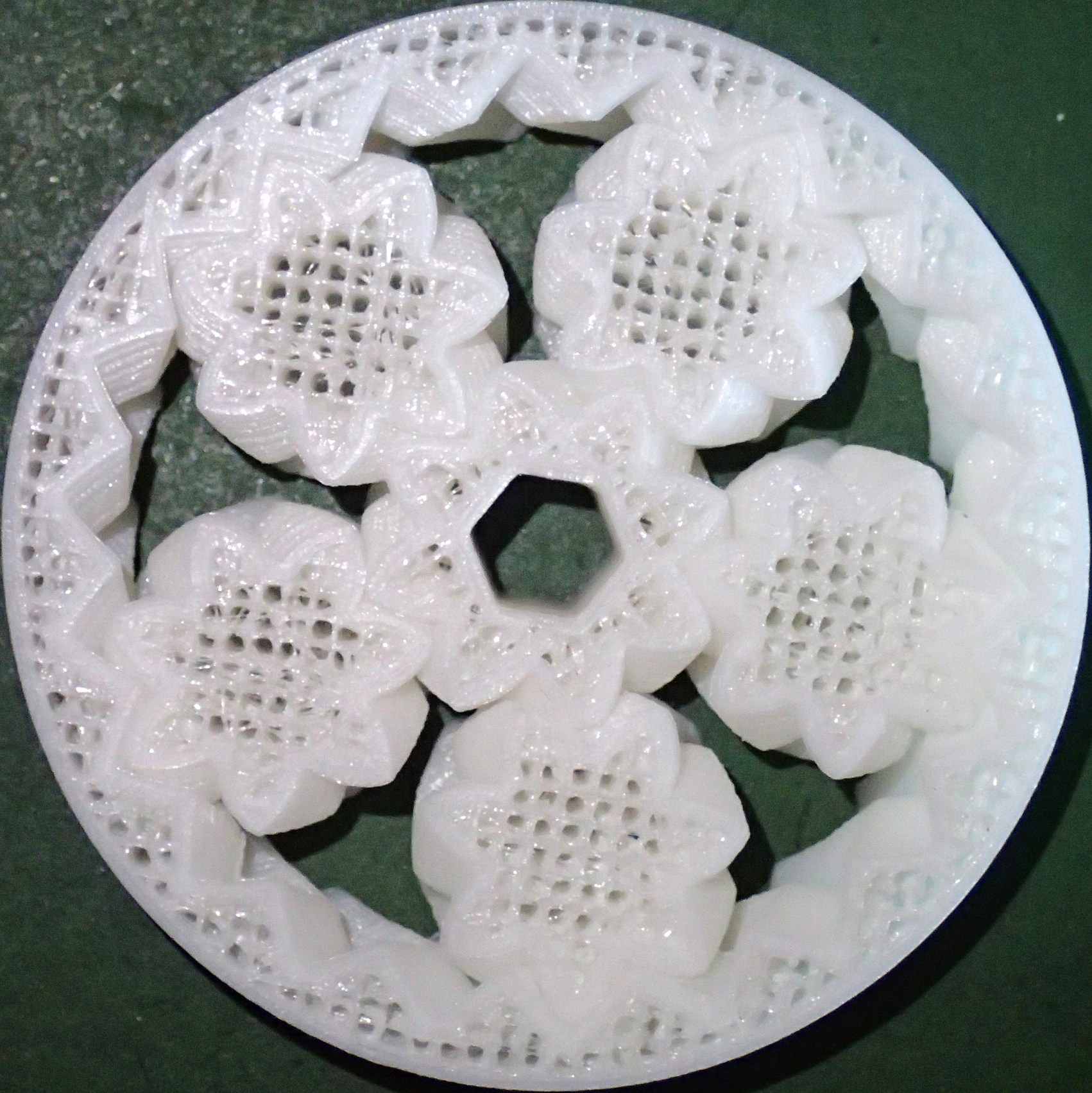 Close-up of a 3D-printed helical planetary gear, showing the printed layers and interlocking mechanical components
